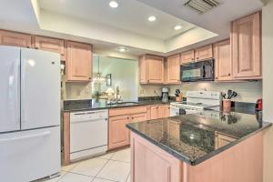 eine Küche mit Holzschränken und einem weißen Kühlschrank in der Unterkunft Sunny Sarasota Villa with Lanai Less Than 5 Mi to Beach in Sarasota
