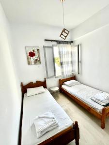 two twin beds in a room with a window at Philoxenia traditional house private jacuzzi in Palaiólimnos +49 photos