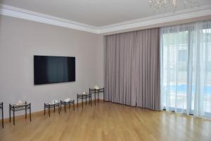 a living room with a flat screen tv and a large window at Villa De France in Yerevan
