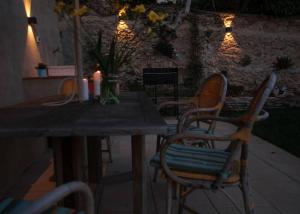 una mesa de madera con sillas y una mesa con velas en IL PICCINO 29, Esperienza Romantica in Borgo...., en Montescudaio