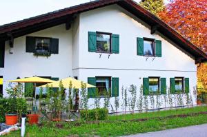 Casa blanca con ventanas con persianas verdes en Atterseeblick - Ferienwohnung Anneliese Kunert en Wildenhag
