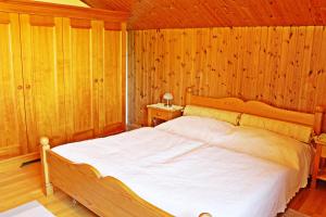 1 dormitorio con 1 cama en una habitación de madera en Atterseeblick - Ferienwohnung Anneliese Kunert en Wildenhag