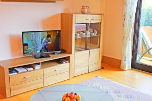 een woonkamer met een tv en een tafel bij Atterseeblick - Ferienwohnung Anneliese Kunert in Wildenhag
