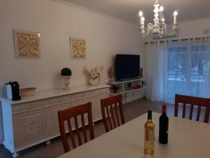 a dining room with a table and a television at Beach Falésia in Albufeira