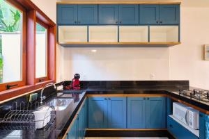 a kitchen with blue cabinets and a sink at Loft Andorinha 3 in Paraty