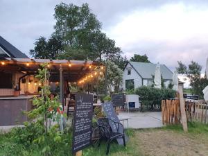 ein Restaurant mit einer Pergola und einem Schild im Hof in der Unterkunft Villa Vemmentorp - Körsbärsblomsvillan 6 min från havet in Skurup