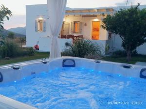 una bañera de hidromasaje frente a una casa en GeoNi's villa & garden spa en Apollonia