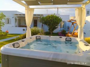 una bañera de hidromasaje en el patio de una casa en GeoNi's villa & garden spa, en Apollonia