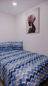 1 cama en un dormitorio con una foto en la pared en parque provenza and lleras minutes away en Medellín