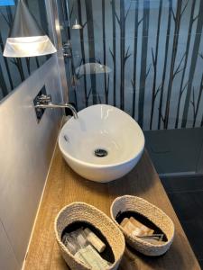 a bathroom with a white sink on a wooden counter at Hotel La Bitta in Marina di Pietrasanta