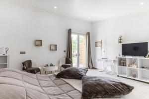 une chambre blanche avec un grand lit et une table dans l'établissement Domaine mon doux rêve, à Terrasson