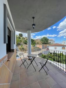 d'une terrasse avec une table et des chaises sur un balcon. dans l'établissement Apartamentos Los Senderos de Tolox, à Tolox