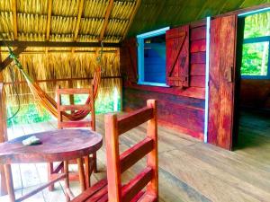 a room with a table and two chairs and a table and a house at Hostal Doble Vista in Capurganá