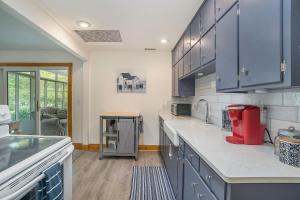 a kitchen with blue cabinets and a red appliance at Tower Hill Cottage in Sawyer