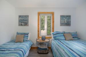 two twin beds in a room with a window at Tower Hill Cottage in Sawyer