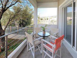 a patio with a table and chairs on a balcony at Almira Ghouse in Almiropotamos