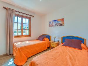 two orange beds in a room with a window at Vv Casa Maruca Accesibilidad - Playa 5 min in Caleta De Fuste
