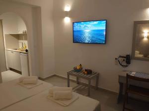 a living room with two beds and a television on the wall at Ikaros Studios in Faliraki