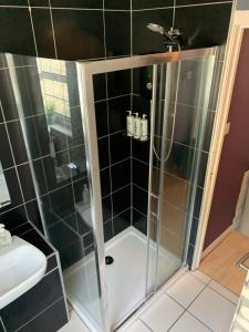 um chuveiro com uma porta de vidro na casa de banho em Stylish apartment in the heart of Inverness em Inverness