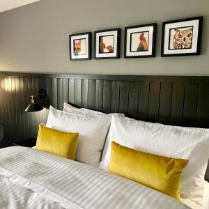 ein Schlafzimmer mit einem weißen Bett und gelben Kissen in der Unterkunft The Jack and Jill Coaching Inn in Saltburn-by-the-Sea