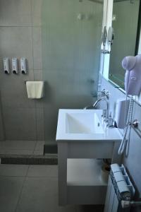 a bathroom with a white sink and a shower at Las Barrancas Apart & Spa in Necochea