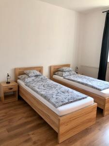 zwei Betten in einem Schlafzimmer mit Holzboden in der Unterkunft Víkendový dom - Divín in Divín