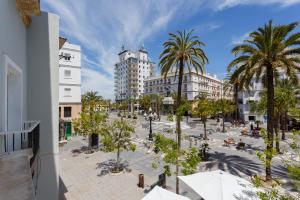 una plaza de la ciudad con palmeras y edificios en Apartamentos El Capitan Veneno by Cadiz4Rentals, en Cádiz