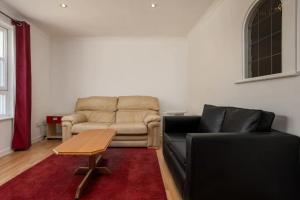 ein Wohnzimmer mit einem Sofa und einem Tisch in der Unterkunft Stylish 2 Bedroom Apartment near the City Centre in Edinburgh
