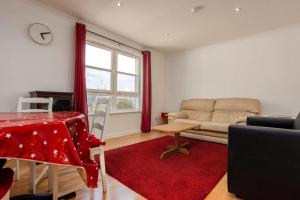 ein Wohnzimmer mit einem Sofa und einem roten Teppich in der Unterkunft Stylish 2 Bedroom Apartment near the City Centre in Edinburgh