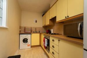 eine Küche mit einer Waschmaschine und einer Waschmaschine in der Unterkunft Stylish 2 Bedroom Apartment near the City Centre in Edinburgh