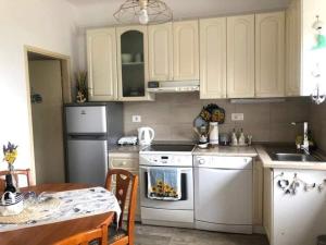 a kitchen with white appliances and a table and a dining room at Istrian house Mojca in Koper