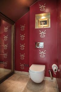 a bathroom with a toilet in a red wall at Janus Vila Karkleje in Karklė