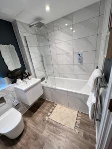 a bathroom with a tub and a toilet and a sink at Windsor, LEGOLAND, Ascot & Windsor RACECOURSE sleeps 3 in Windsor