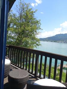 a balcony with chairs and a view of the water at Seehaus traumhaft Wörthersee in Tiebitsch
