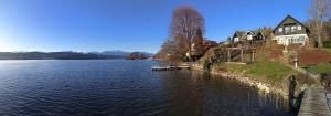 - une vue sur un lac avec des maisons sur la rive dans l'établissement Seehaus traumhaft Wörthersee, à Tiebitsch