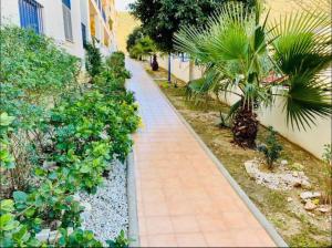 einen Bürgersteig neben einem Gebäude mit Pflanzen in der Unterkunft Luxurious aparment benalmadena in Málaga