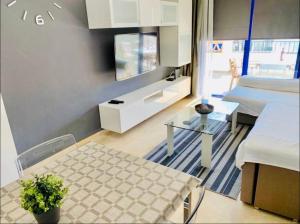 ein Wohnzimmer mit einem Tisch und einem TV in der Unterkunft Luxurious aparment benalmadena in Málaga