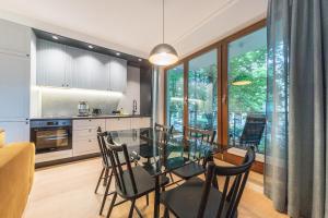 a kitchen and dining room with a glass table and chairs at Pomorskie Apartamenty Aquarius in Sopot