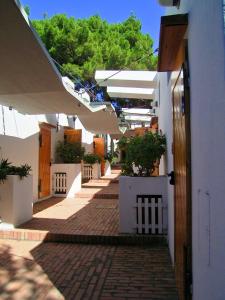 a hallway of a white building with a brick walkway at Hotel Kyrie Isole Tremiti in San Domino