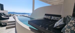 ein Wohnzimmer mit einem Sofa neben einem Pool in der Unterkunft Galaxy Suites & Villas in Imerovigli