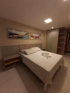a bedroom with a large white bed in a room at Tambaú Israel Flat 417 - Beira mar in João Pessoa