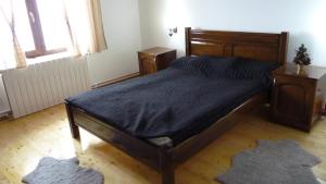 a bedroom with a wooden bed with a blue comforter at Cabana Telescaun in Petroşani