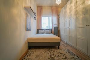 um pequeno quarto com uma cama e uma janela em Gardenhill Vienna em Viena