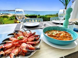 a table with a plate of shrimp and a bowl of soup at Puerto Velero Primera Línea Primer Piso con Jardín, Piscina y Playa! 7pax in Puerto Velero