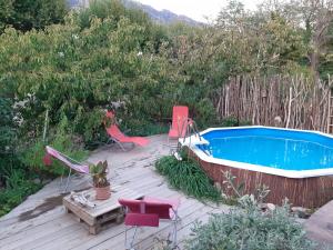 a deck with a swimming pool and chairs and a table at Les Violettes in Mons