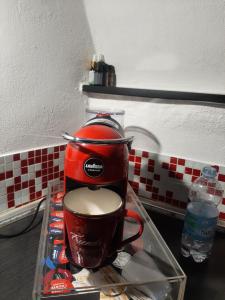 uma máquina de café vermelha sentada em cima de uma mesa em ROSEROSSE casa vacanze em Sanremo