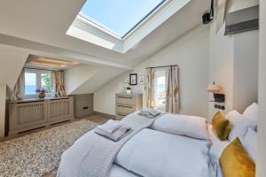 a bedroom with a large white bed with a skylight at Goldmädchen 93 - Honeymoon Suite in Timmendorfer Strand