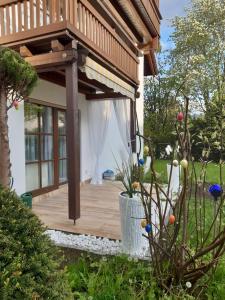 una terraza de madera con pérgola en un patio en Ferienwohnung Dana en Murnau am Staffelsee