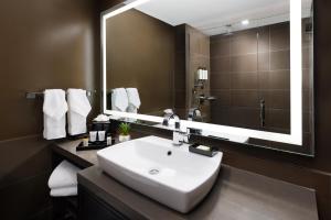 a bathroom with a sink and a large mirror at M Social Hotel Times Square New York in New York