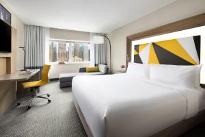 a hotel room with a large bed and a desk at M Social Hotel Times Square New York in New York